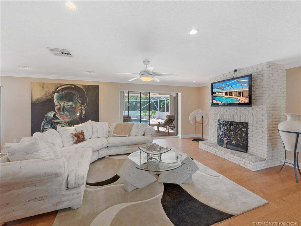 853 Northwest Spruce Ridge Drive Stuart, FL 34994 - Photo 11 of 20 a living room with furniture a fireplace and a flat screen tv