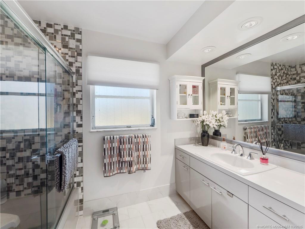 853 Northwest Spruce Ridge Drive Stuart, FL 34994 - Photo 15 of 20 a en suite bathroom with sink mirror and