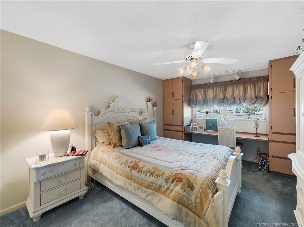 853 Northwest Spruce Ridge Drive Stuart, FL 34994 - Photo 16 of 20 a bedroom with a bed and a chandelier