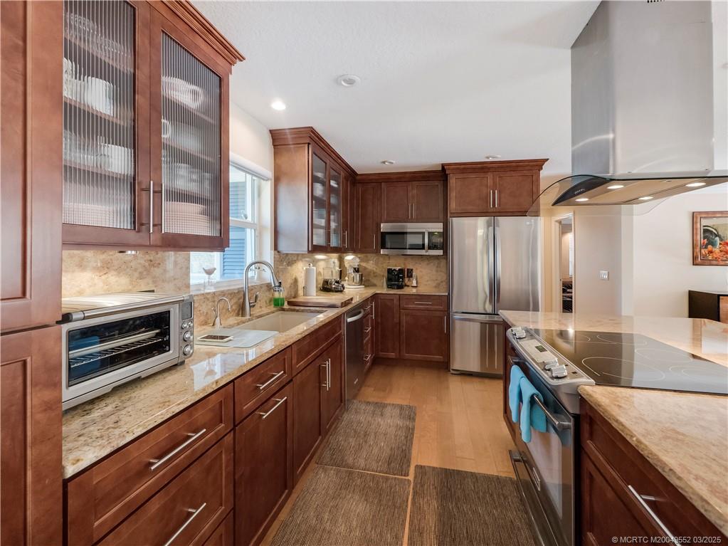 853 Northwest Spruce Ridge Drive Stuart, FL 34994 - Photo 7 of 20 a kitchen with stainless steel appliances granite countertop a sink a stove and a refrigerator