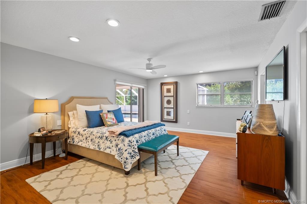 853 Northwest Spruce Ridge Drive Stuart, FL 34994 - Photo 8 of 20 a bedroom with a bed and wooden floor