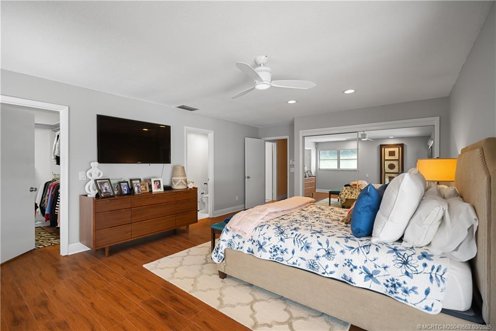 853 Northwest Spruce Ridge Drive Stuart, FL 34994 - Photo 10 of 20 a bedroom with a bed and a flat screen television