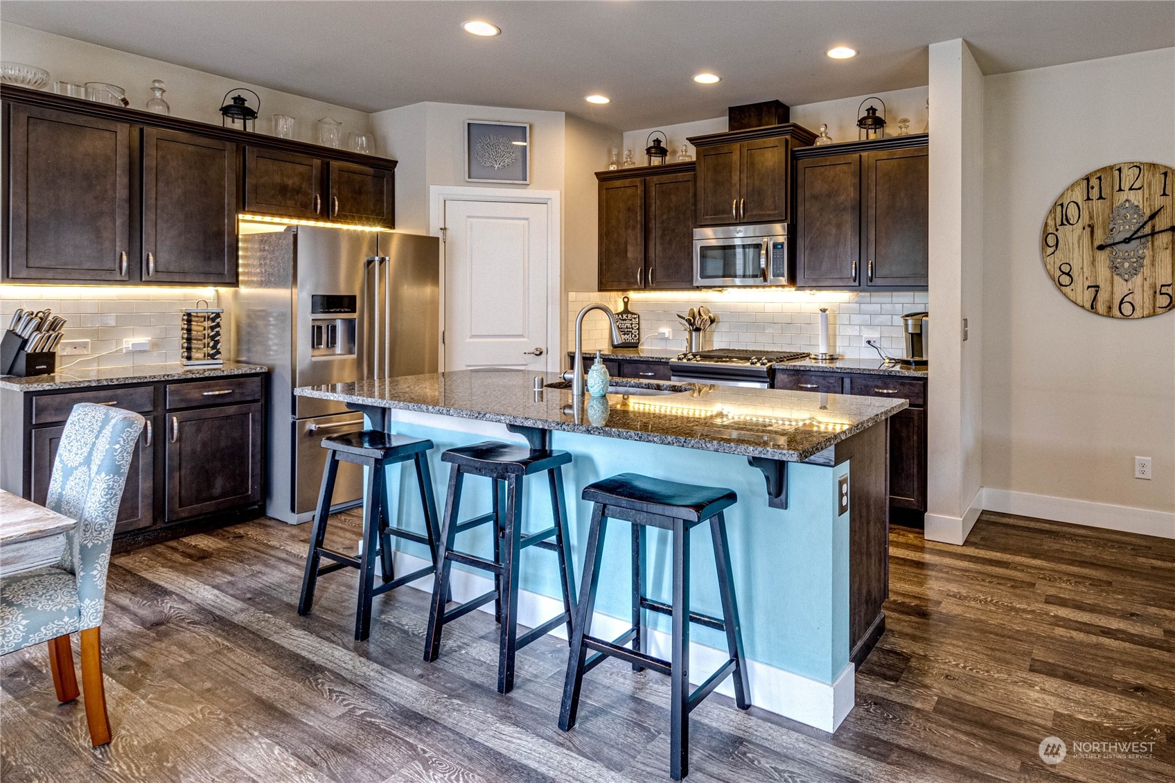 222 202nd Street Southeast Bothell, WA 98012 - Photo 9 of 37 a kitchen with stainless steel appliances a refrigerator a stove a sink dishwasher with a dining table and chairs