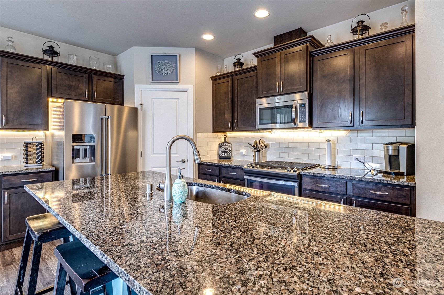 222 202nd Street Southeast Bothell, WA 98012 - Photo 10 of 37 a kitchen with kitchen island granite countertop a table chairs microwave and refrigerator