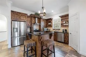 a kitchen with stainless steel appliances granite countertop a refrigerator and a stove