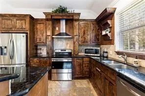 a kitchen with stainless steel appliances granite countertop a sink and a refrigerator