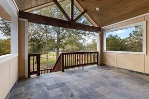 a view of a hallway with wooden floor and a window