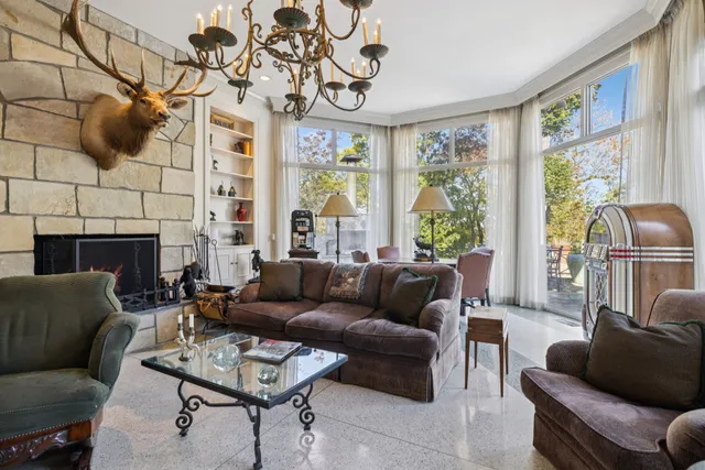 a view of a hallway with chandelier and glass door