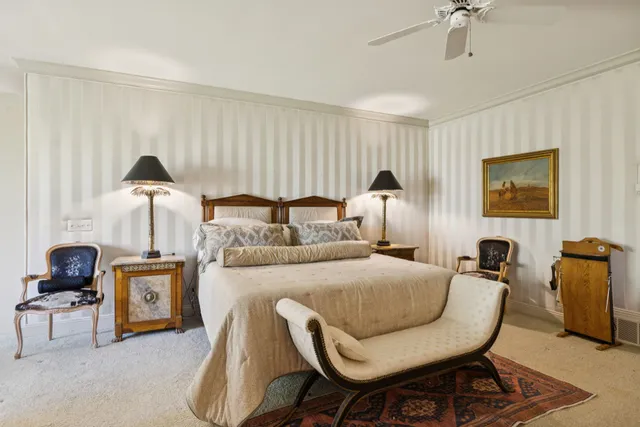 a view of a backyard with table and chairs plants and large trees