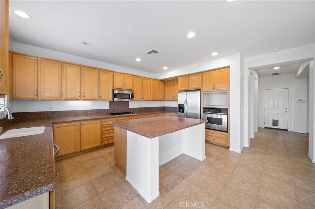 33710 Sattui Street Temecula, CA 92592 - Photo 11 of 75 a kitchen with stainless steel appliances granite countertop a refrigerator and a stove top oven