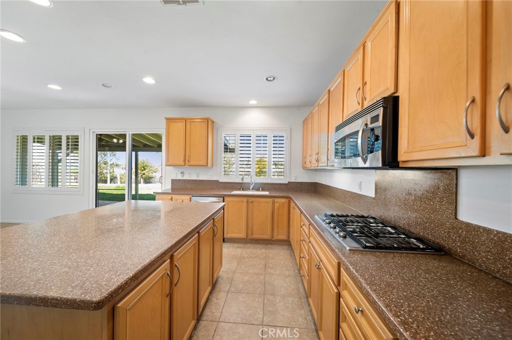 33710 Sattui Street Temecula, CA 92592 - Photo 12 of 75 a kitchen with a stove a sink and a refrigerator