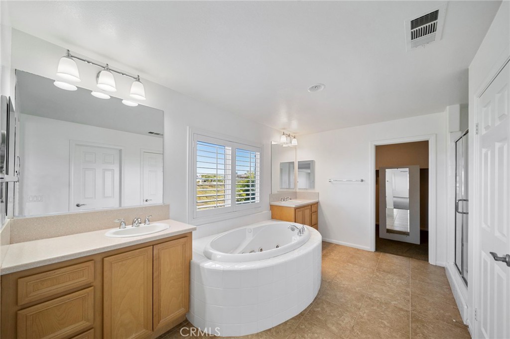 33710 Sattui Street Temecula, CA 92592 - Photo 34 of 75 a bathroom with a tub a sink and a large mirror