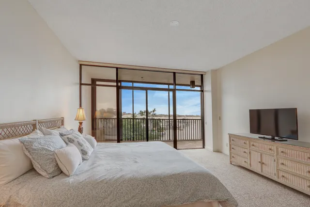 a bedroom with a large bed and a flat screen tv