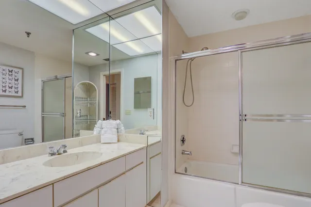 a bathroom with a shower sink vanity and mirror