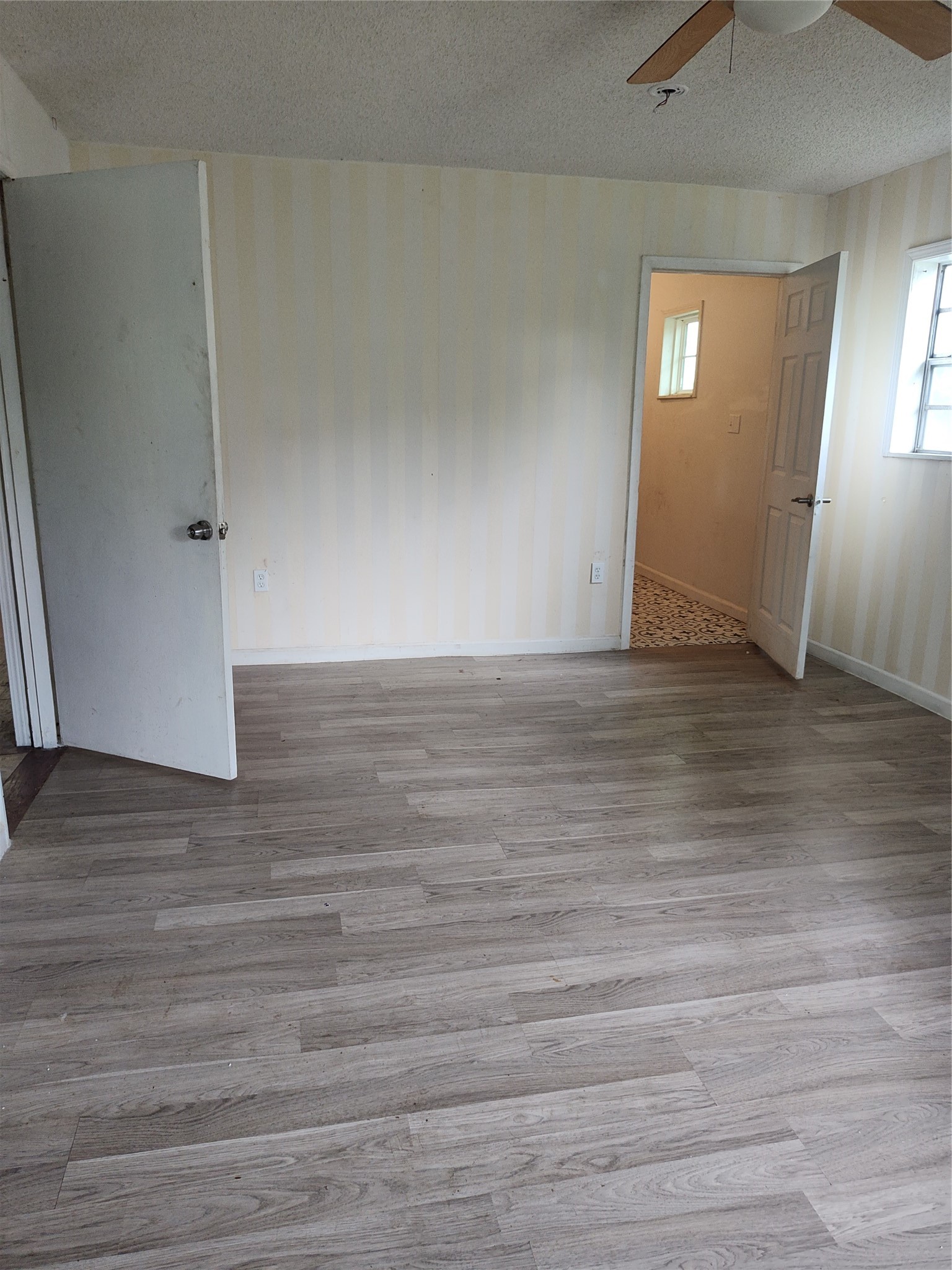 527 West 6th Street Freeport, TX 77541 - Photo 9 of 25 a view of an empty room with wooden floor and a window