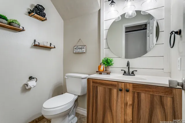 a bathroom with a toilet sink and mirror