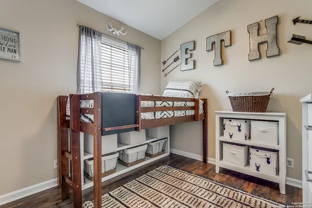 a view of a bedroom with baby crib and hanging chair