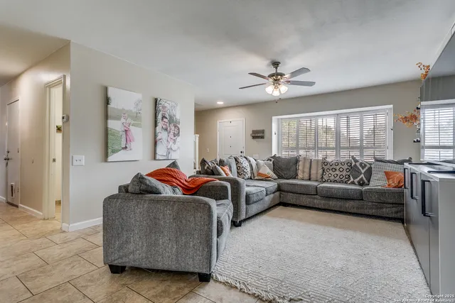 a living room with furniture and a ceiling fan