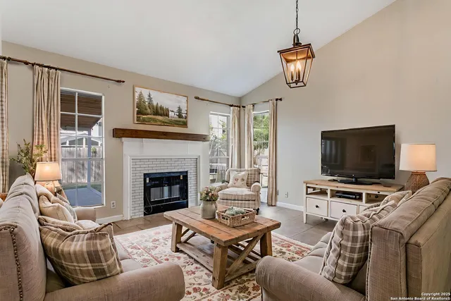 a living room with furniture a flat screen tv and a fireplace
