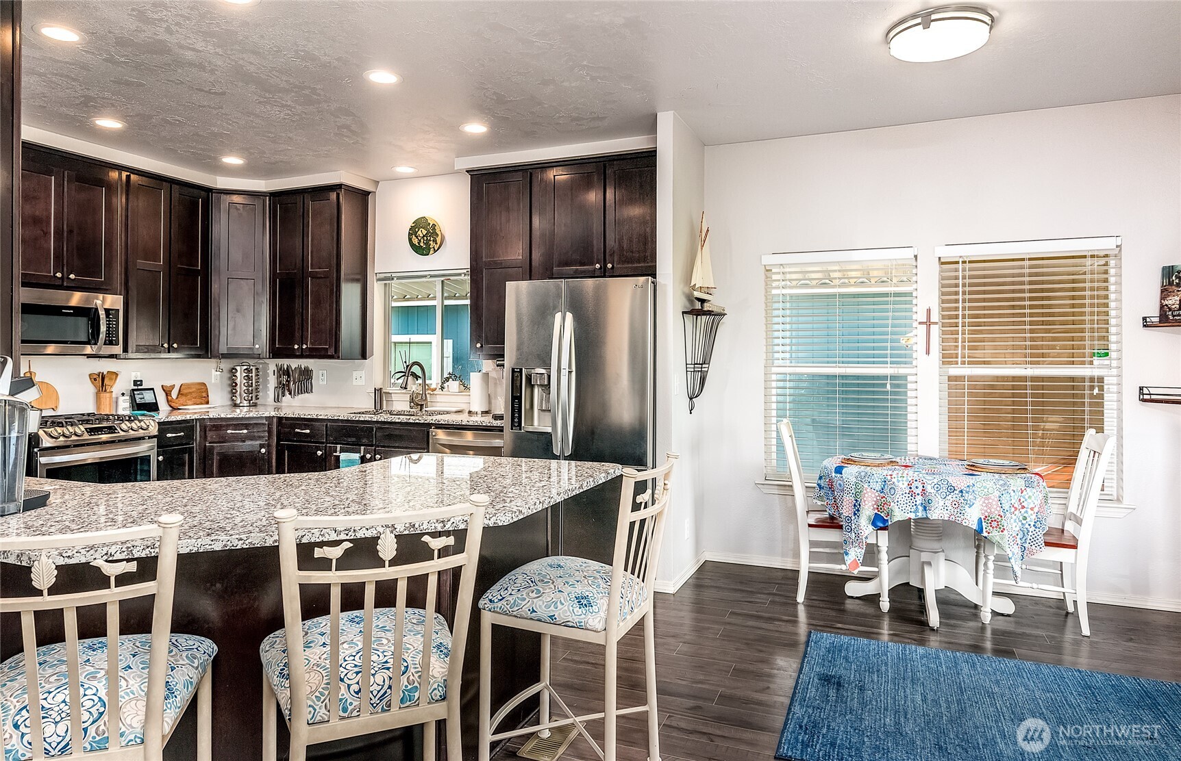 2101 South 324th Street, Unit 53 Federal Way, WA 98003 - Photo 9 of 38 a kitchen with stainless steel appliances granite countertop a stove top oven a sink a dining table and chairs