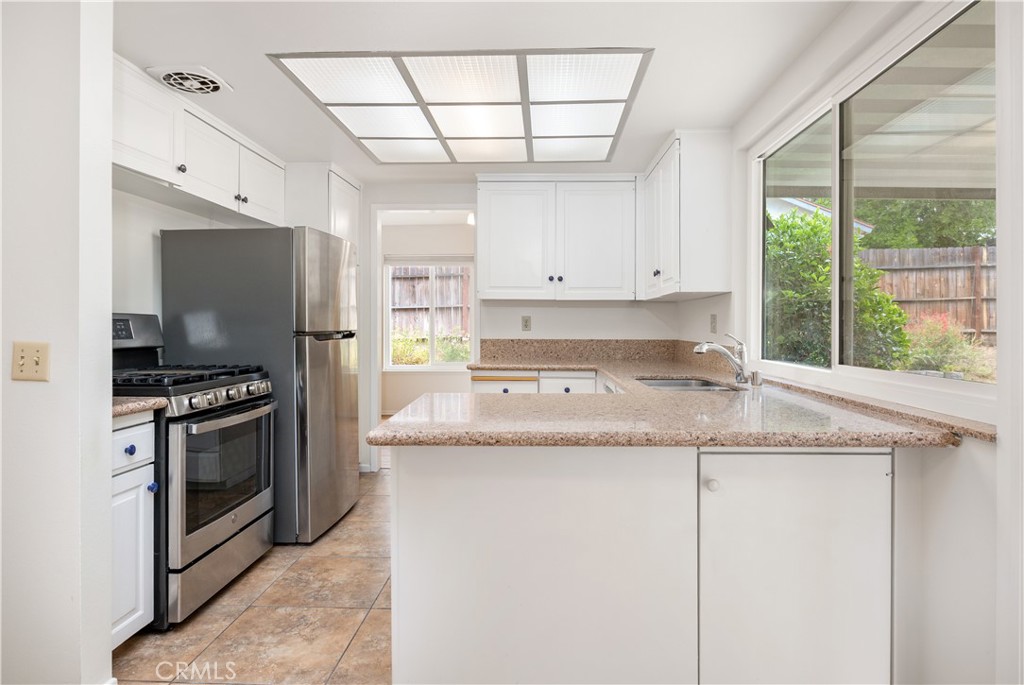 3430 Bahia Place Riverside, CA 92507 - Photo 16 of 34 a kitchen with granite countertop a sink stainless steel appliances a window and a counter top space