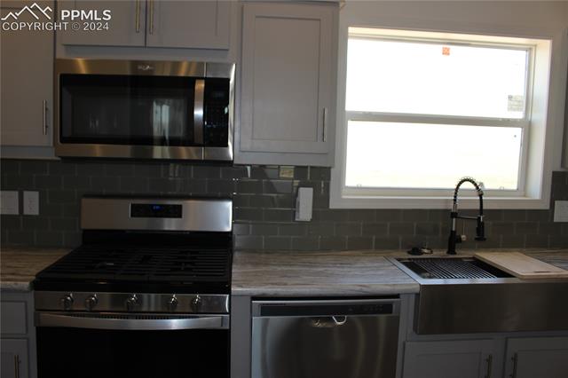 40391 Gieck Road Rush, CO 80833 - Photo 7 of 17 Kitchen featuring tasteful backsplash, and appliances with stainless steel farm sink