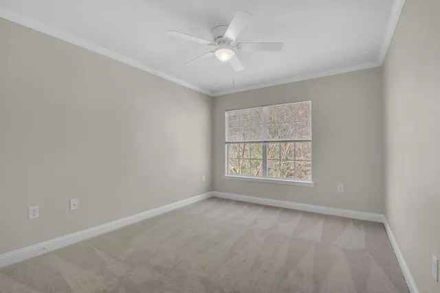 an empty room with a window and a ceiling fan