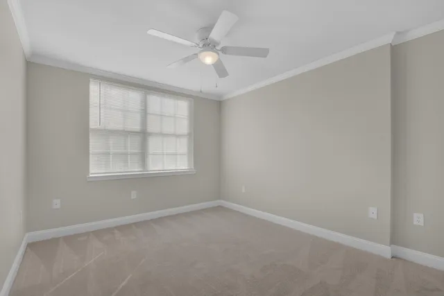an empty room with a window and a fan