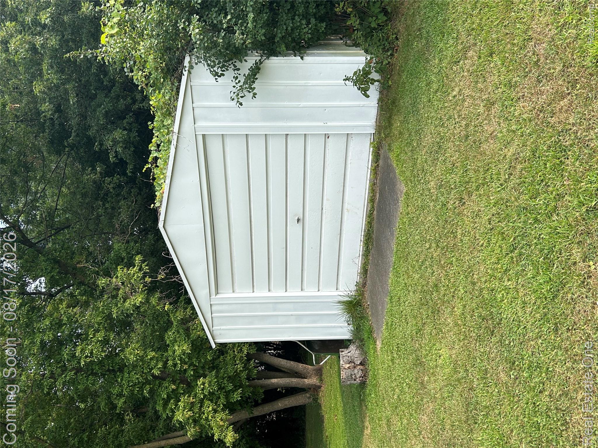 22967 Northline Road Taylor, MI 48180 - Photo 21 of 22 Exterior storage shed with a roll-up door and concrete pad