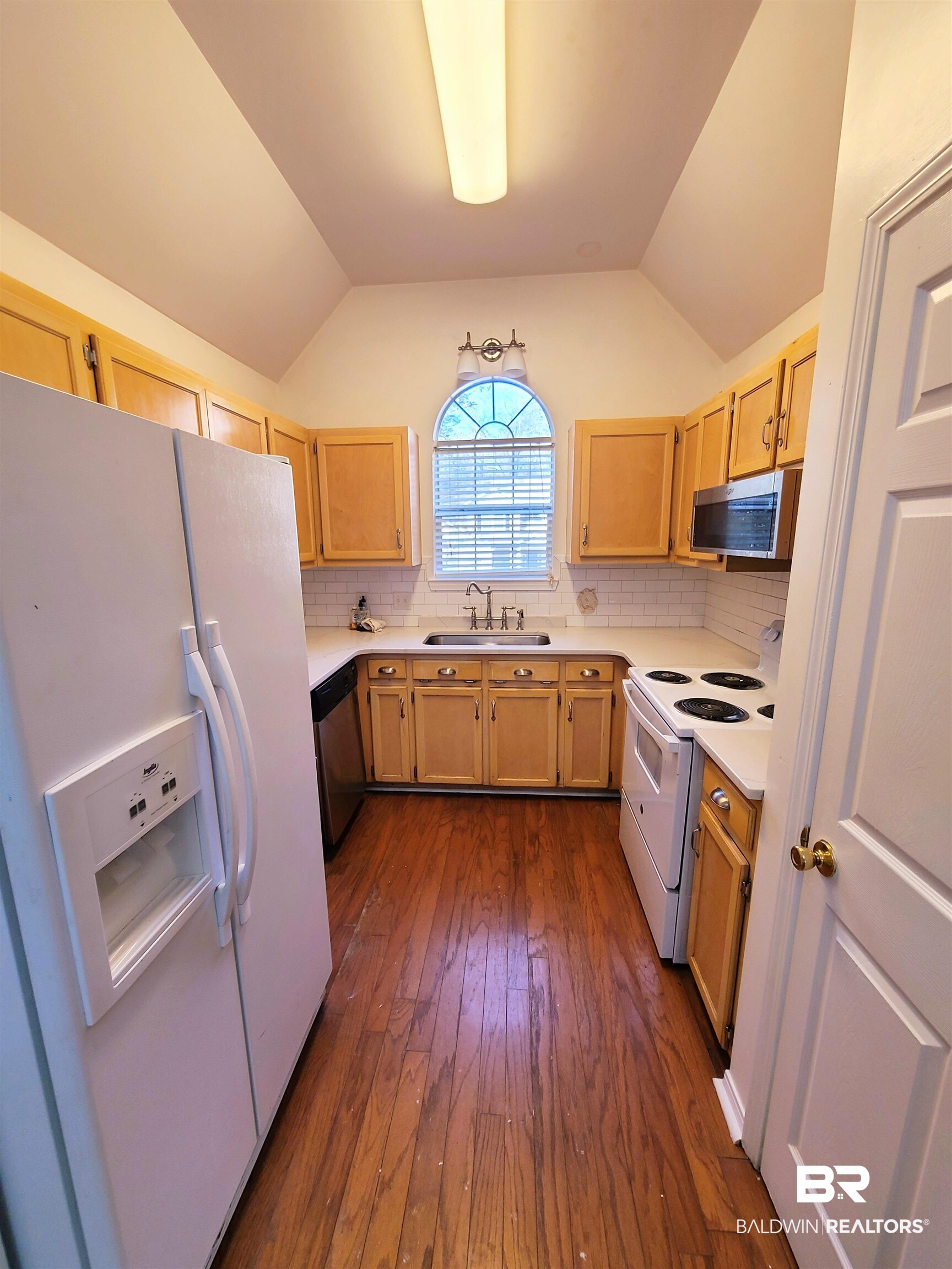 123 Melanie Loop Daphne, AL 36526 - Photo 6 of 17 Kitchen featuring stainless steel appliances, light countertops, lofted ceiling, dark wood finished floors, and decorative backsplash