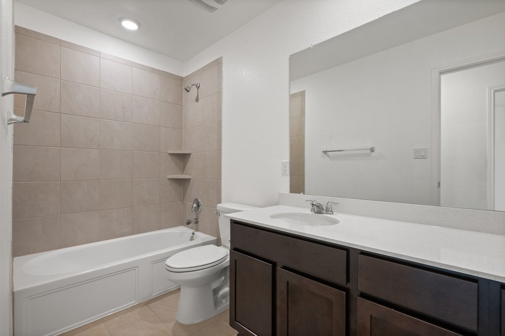 1233 Sweetspire Street Leander, TX 78641 - Photo 20 of 40 The well-appointed 2nd floor guest bathroom features a deep soaking tub and a sleek vanity with ample counter space.