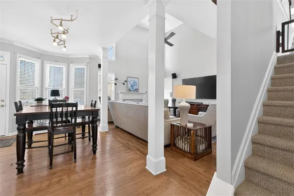 a kitchen with a stove a refrigerator a sink dishwasher a dining table and chairs with wooden floor