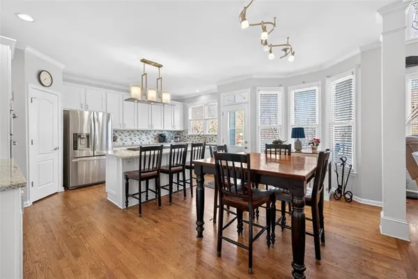 a large kitchen with a stove a sink dishwasher a refrigerator and a oven with wooden floor