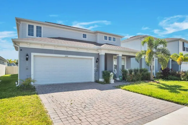 a front view of a house with a yard and potted plants