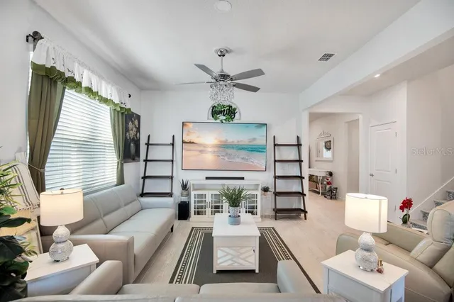 a living room with furniture a large window and a chandelier