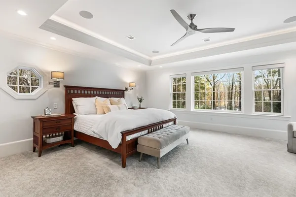 a bed sitting in a spacious bedroom next to a window