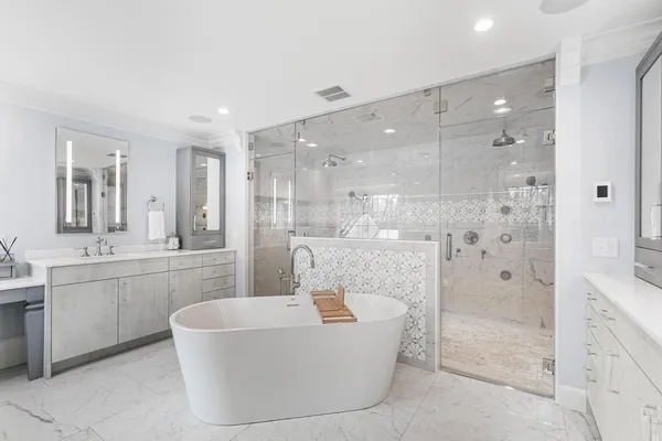 a bathroom with a large tub a sink shower and mirror