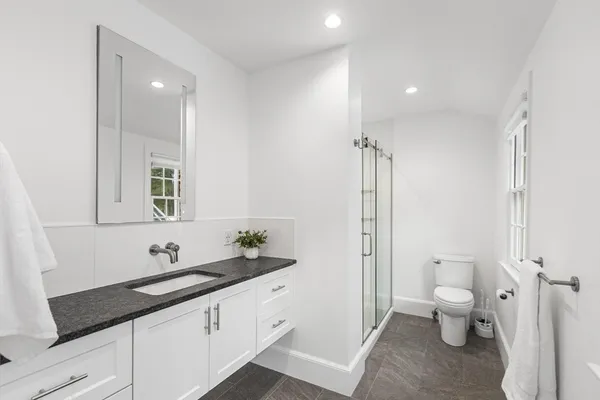a spacious bathroom with a double vanity sink toilet and shower