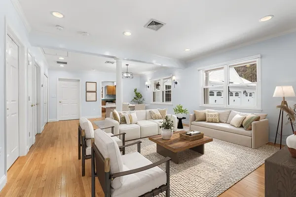 a living room with furniture wooden floor and a large window