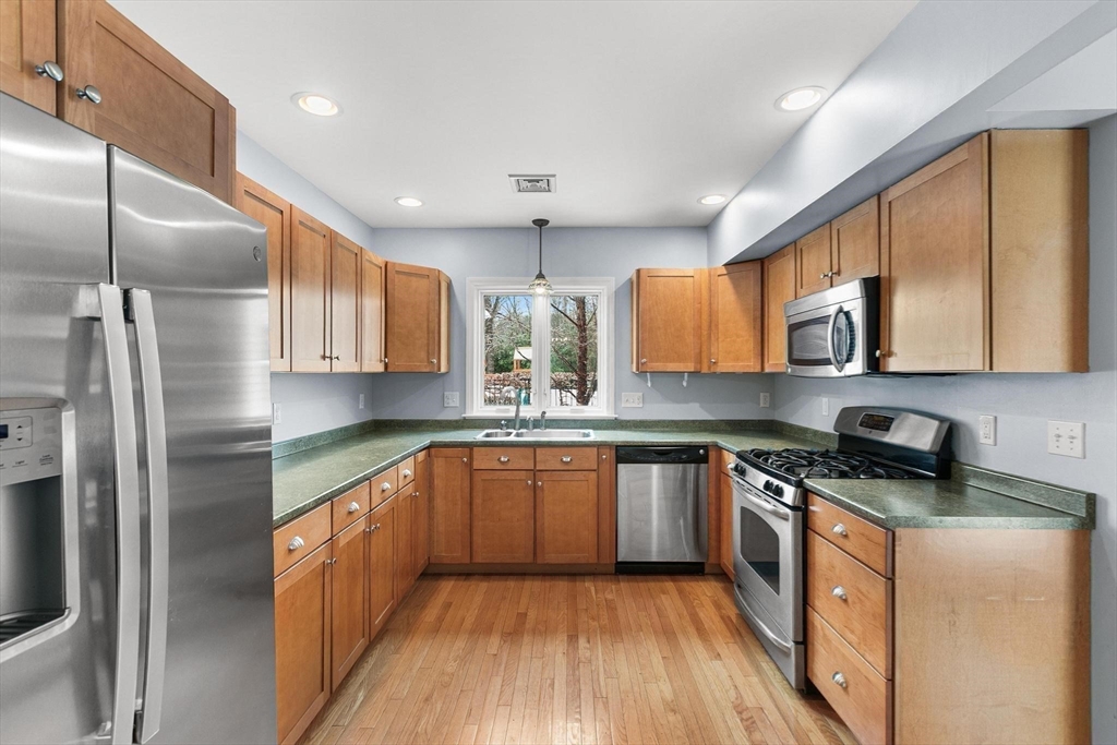 40 Grandview Road Chelmsford, MA 01824 - Photo 32 of 42 a kitchen with stainless steel appliances granite countertop wooden cabinets a refrigerator a sink a stove a microwave and wooden floors