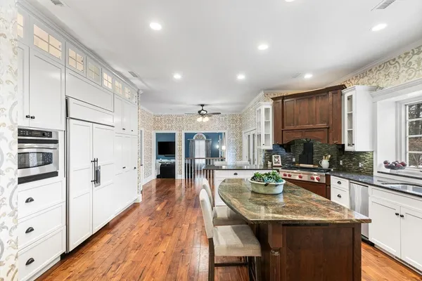 a kitchen with stainless steel appliances granite countertop sink stove refrigerator and cabinets