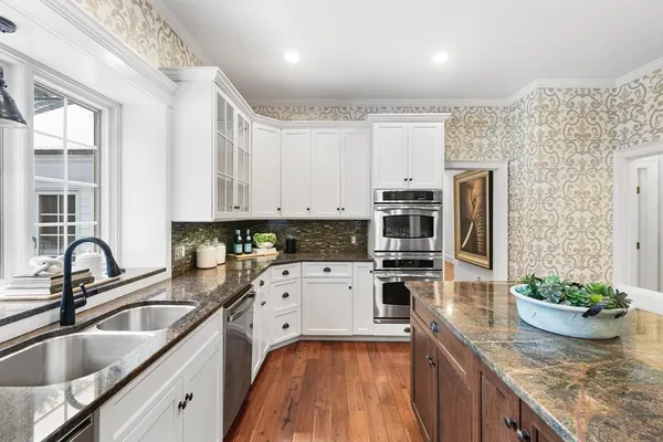 a kitchen with kitchen island granite countertop a sink stainless steel appliances and cabinets