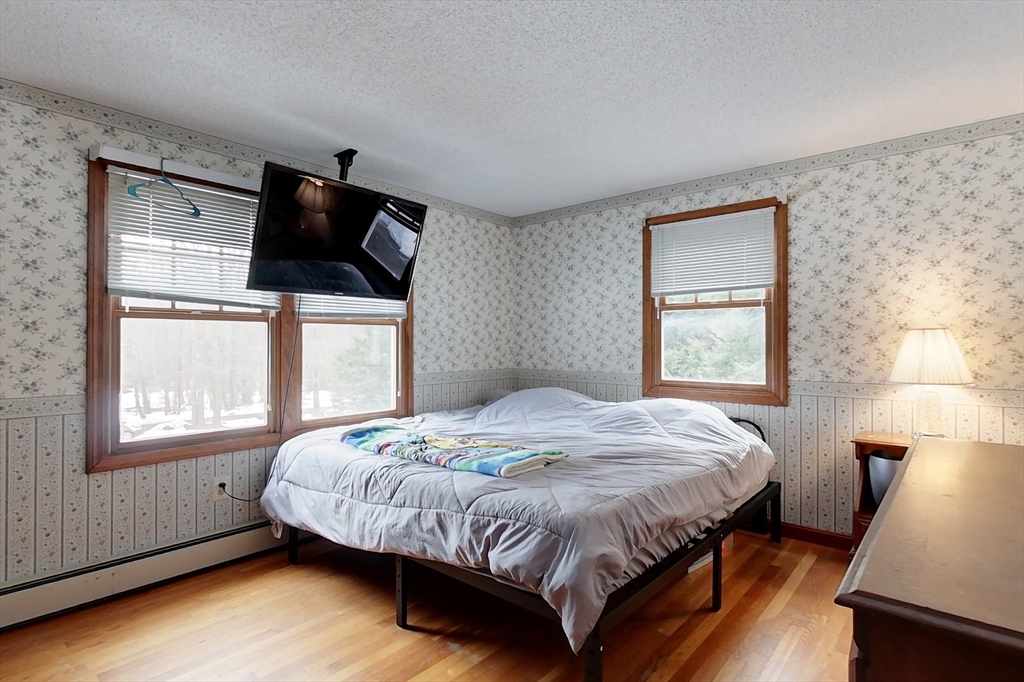 45 Watatic Mountain Road Ashby, MA 01431 - Photo 12 of 31 a bed sitting in a bedroom next to a window