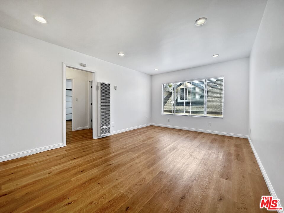 2841 South Sycamore Avenue, Unit 3 Los Angeles, CA 90016 - Photo 3 of 16 an empty room with wooden floor and windows