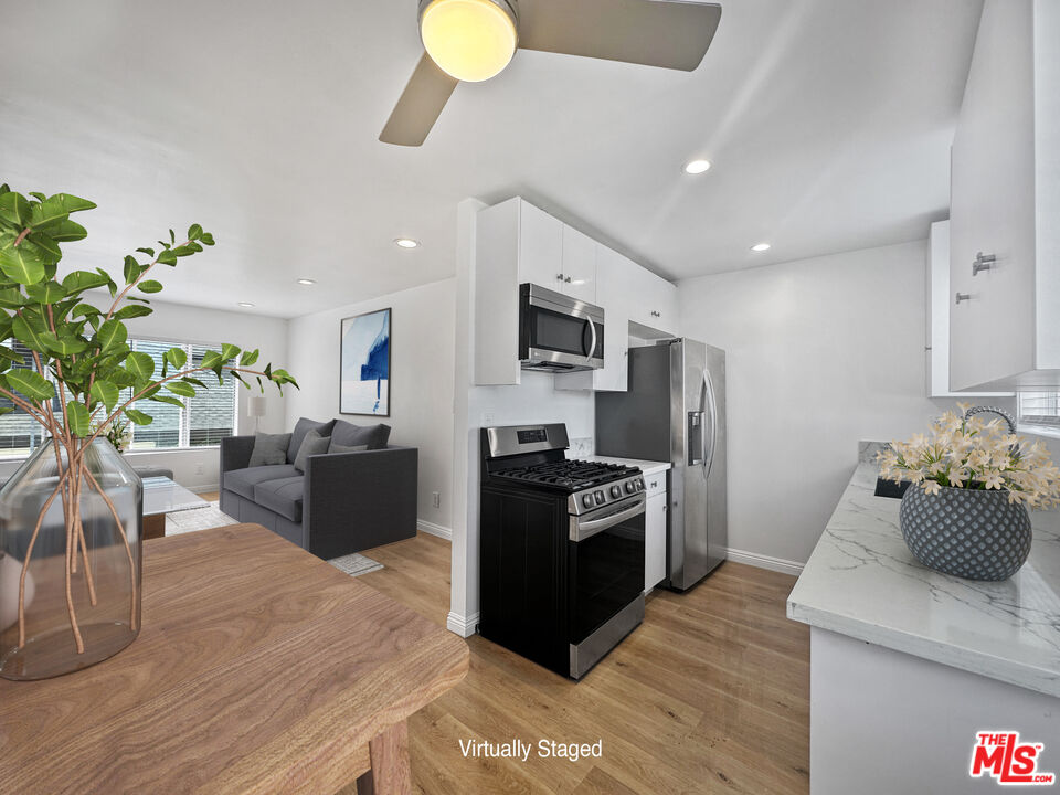 2841 South Sycamore Avenue, Unit 3 Los Angeles, CA 90016 - Photo 4 of 16 a kitchen with stainless steel appliances kitchen island granite countertop a sink and a stove