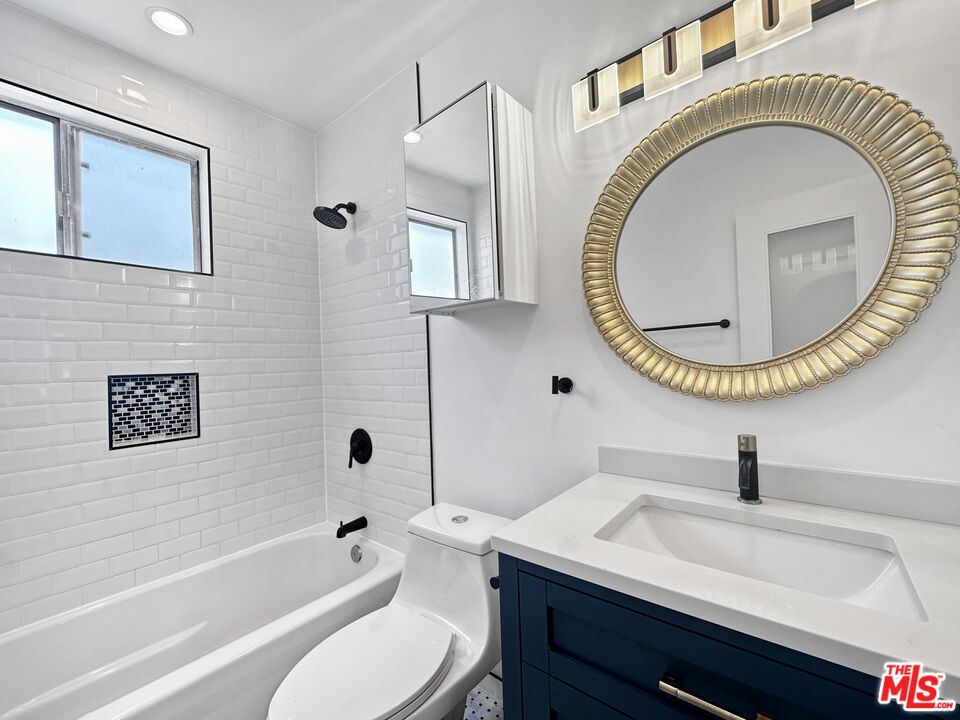 2841 South Sycamore Avenue, Unit 3 Los Angeles, CA 90016 - Photo 9 of 16 a bathroom with a toilet a sink and a mirror