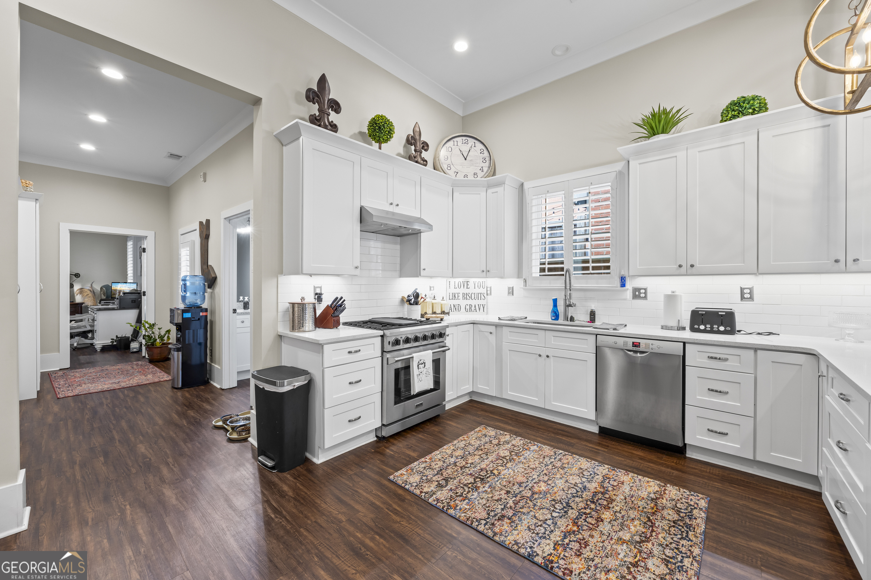 4121 North Swann Street Covington, GA 30014 - Photo 15 of 46 a kitchen with a sink stove and white cabinets with wooden floor