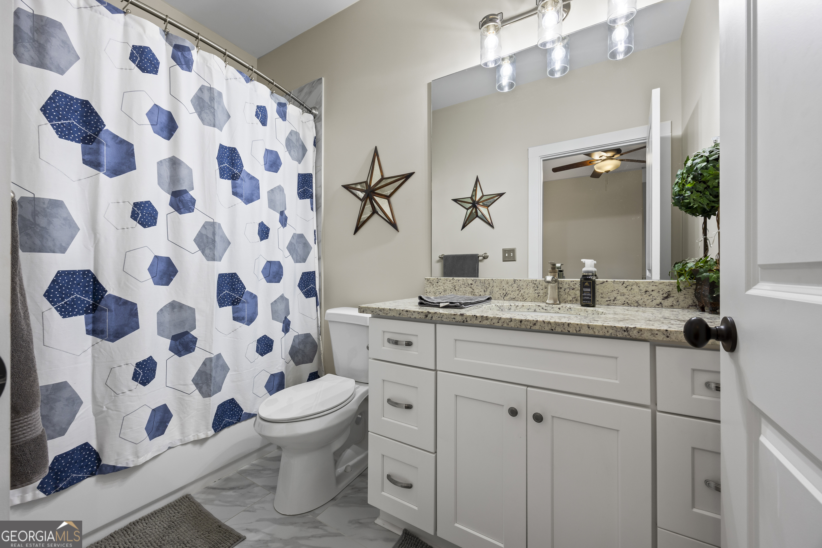 4121 North Swann Street Covington, GA 30014 - Photo 32 of 46 a bathroom with a granite countertop sink a toilet and a mirror