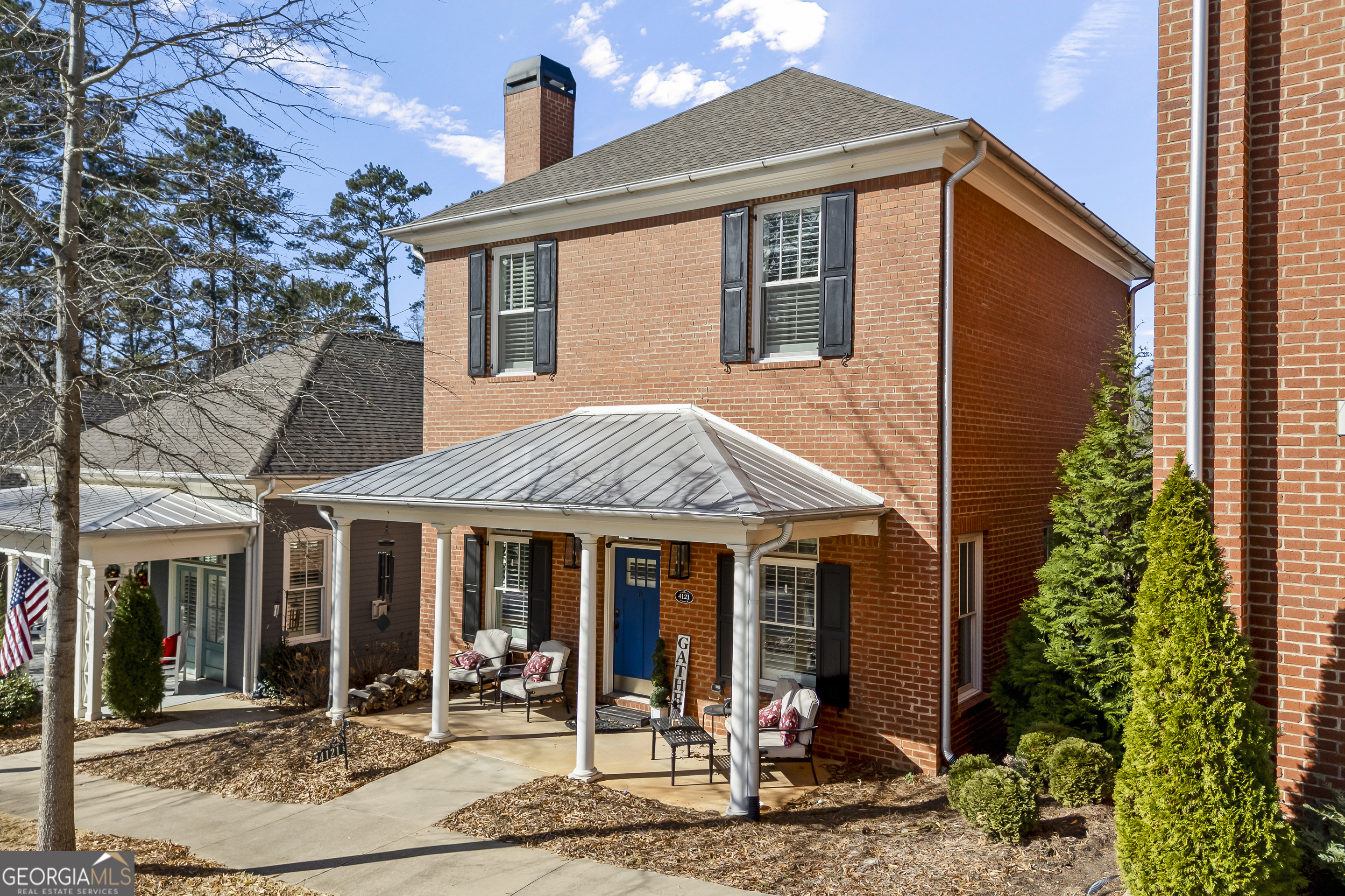 4121 North Swann Street Covington, GA 30014 - Photo 4 of 46 a view of a white house with potted plants and a dining table under an umbrella