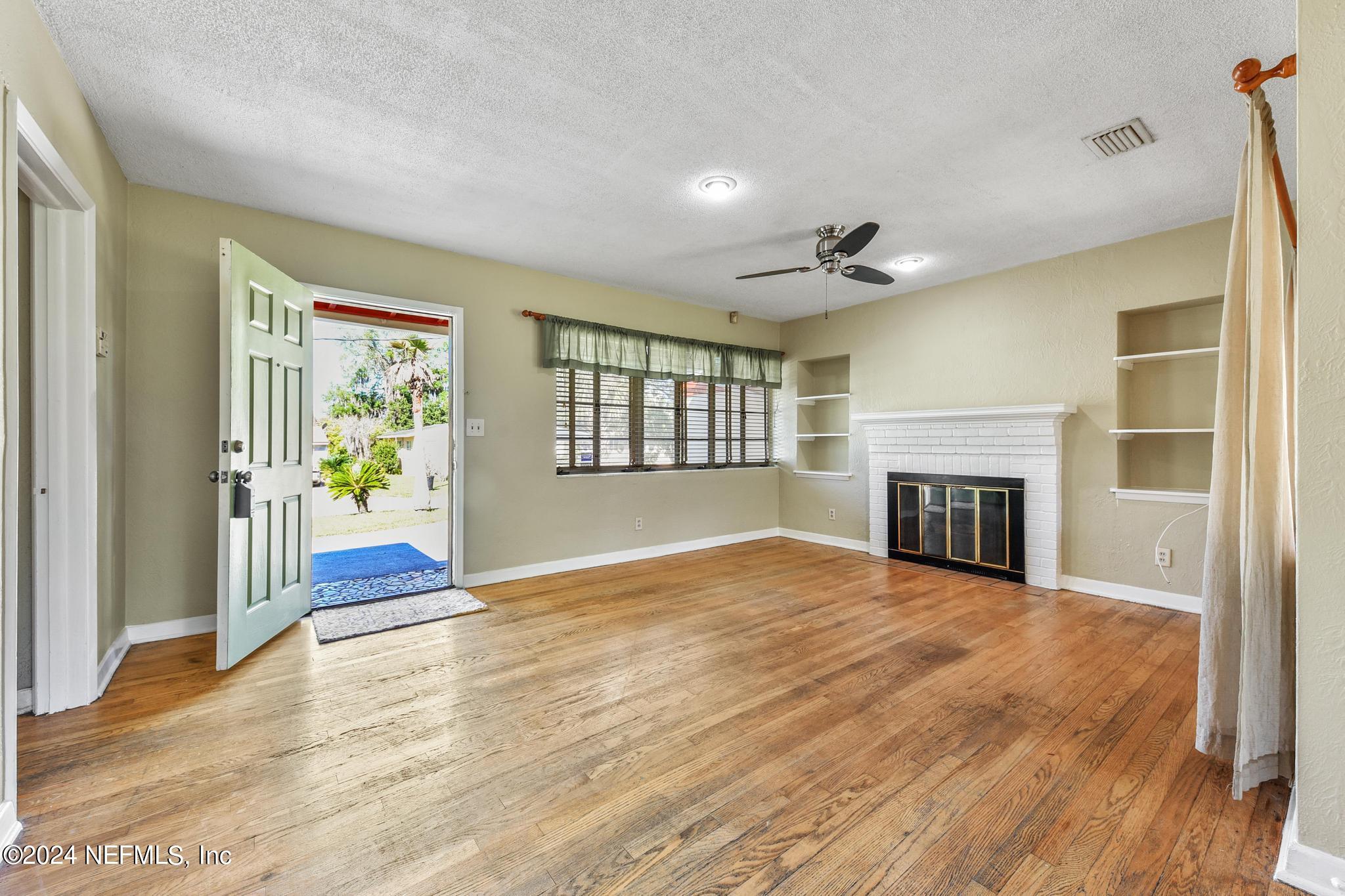 6029 Duke Road Jacksonville, FL 32217 - Photo 5 of 23 a view of an empty room with wooden floor and a window